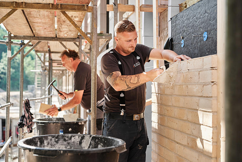 Zwei Maurer*innen des Bauunternehmens Höft Bau bei der Arbeit